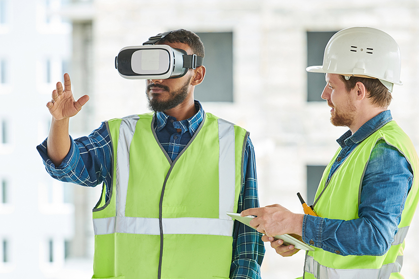 Waist up portrait of two modern construction workers using VR gear to visualize projects on site, copy space