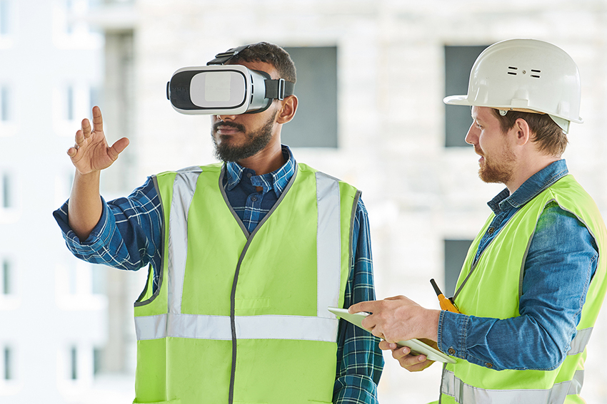 Waist up portrait of two modern construction workers using VR gear to visualize projects on site, copy space