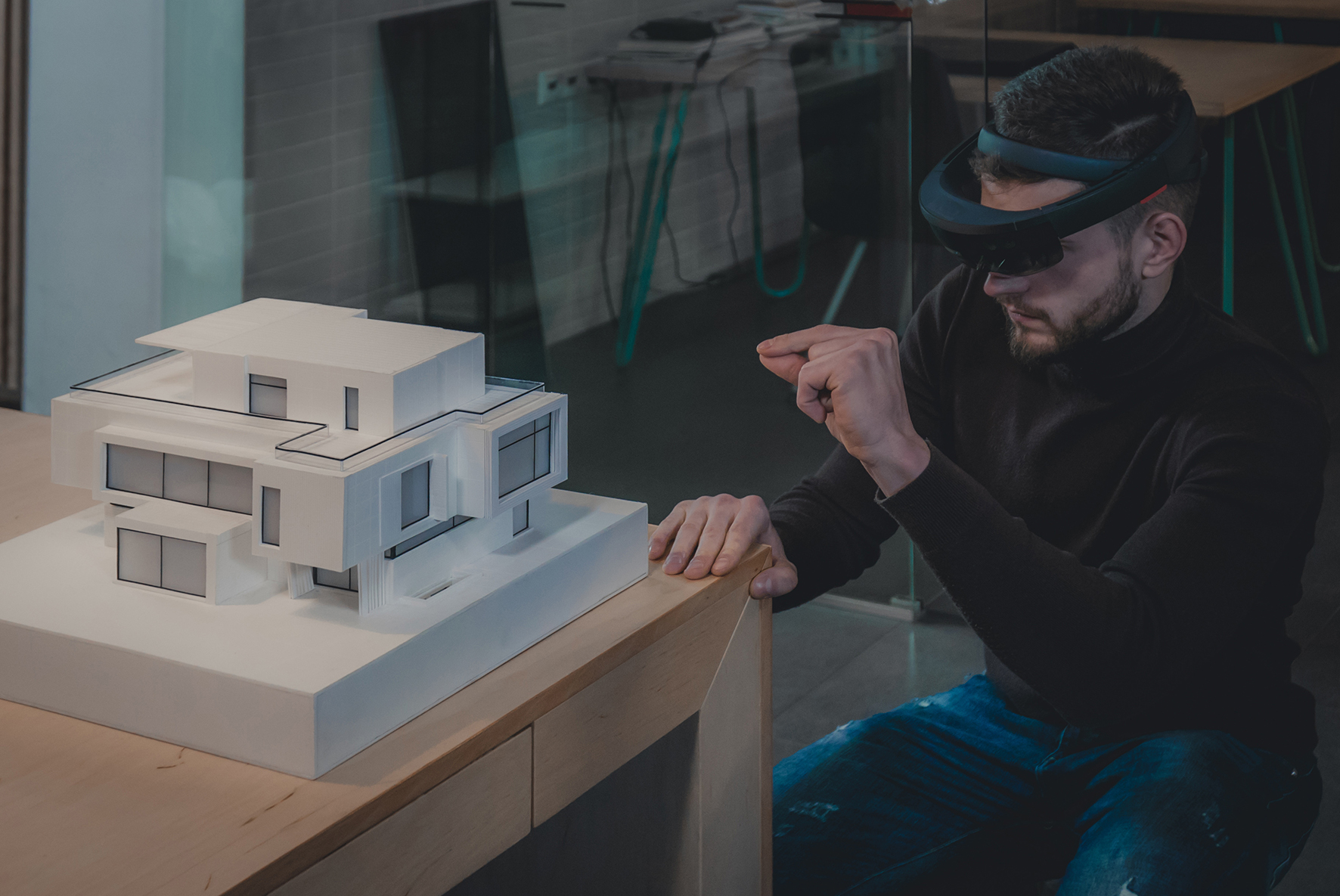 Young confident Caucasian male architect working on a private house project in the office using augmented reality glasses