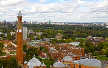 A wide landscape shot of the University of Birmingham with Birmingham City Centre in the far background