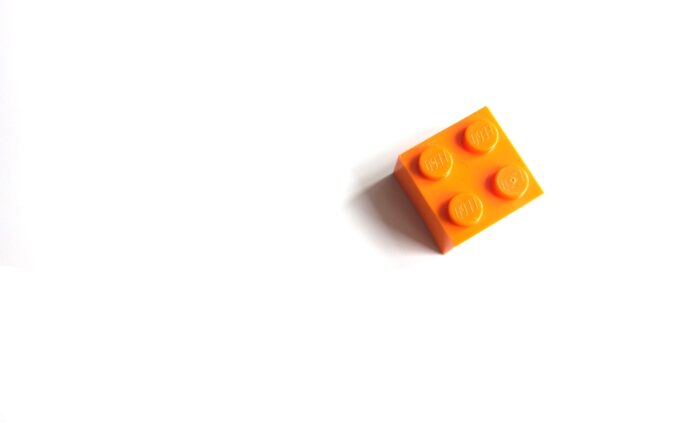 An orange Lego brick against a white background