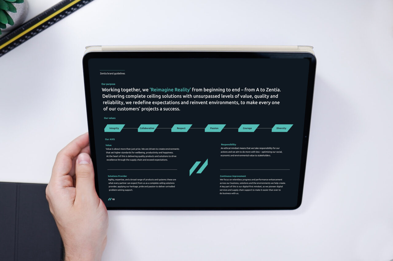 An electronic tablet showing the Zentia brand guidelines, a hand holds up the tablet