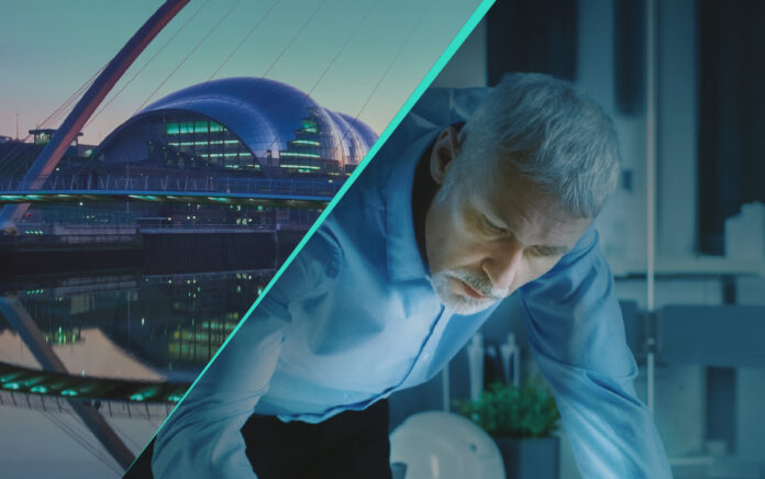 A man in a blue shirt leaning over and the millennium bridge