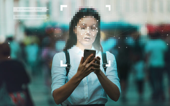 A mid height shot of a woman with the face blurred out and digital iconography pasted over