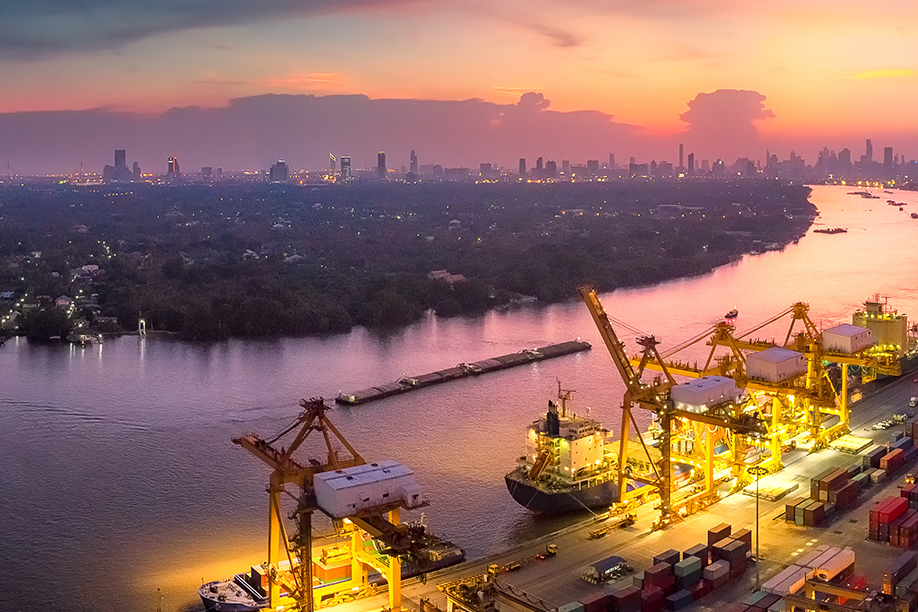 A wide landscape shot of a sunset over dock with a cityscape in the background