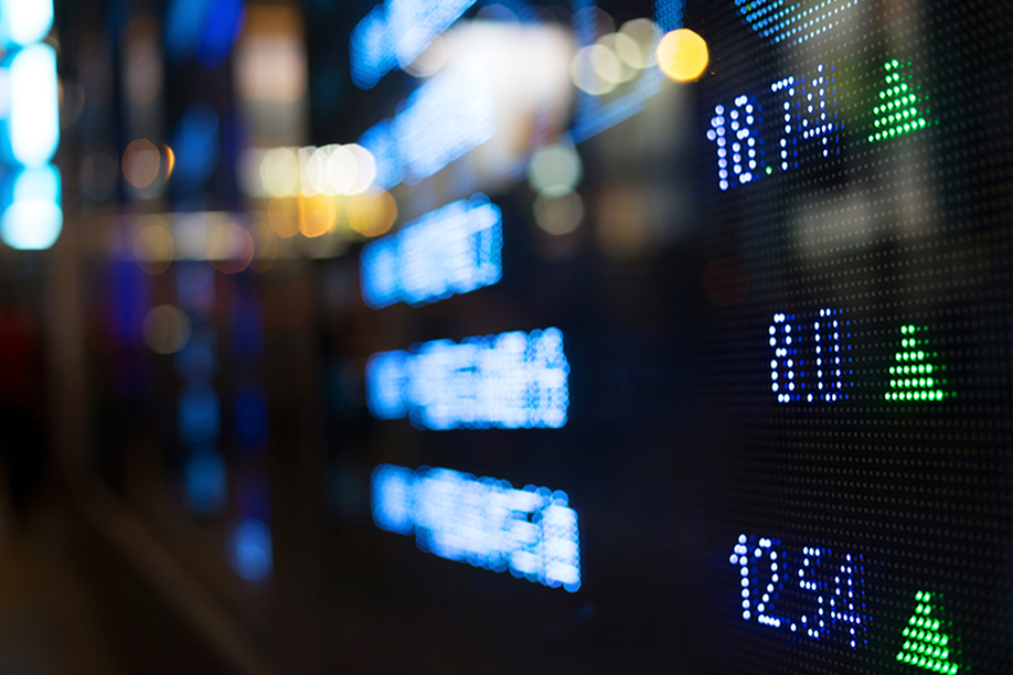 A close up shot of a digital screen, displaying numbers and stock market information