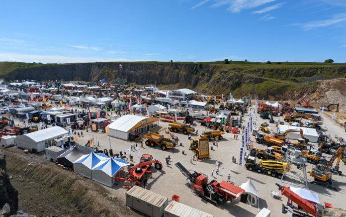 A wide shot photograph of an outdoor exhibition of engineering and farming vehicles