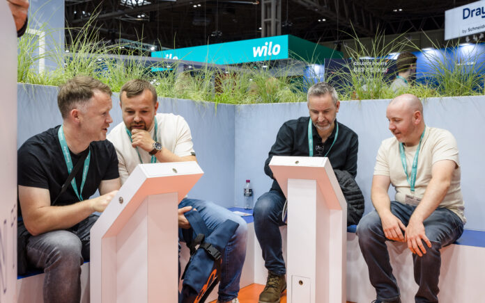 A group of men having a conversation at Navien UK's stand at the installer show.