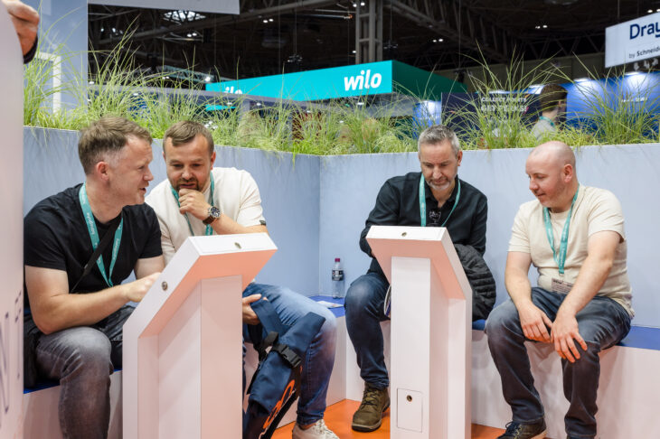 A group of men having a conversation at Navien UK's stand at the installer show.