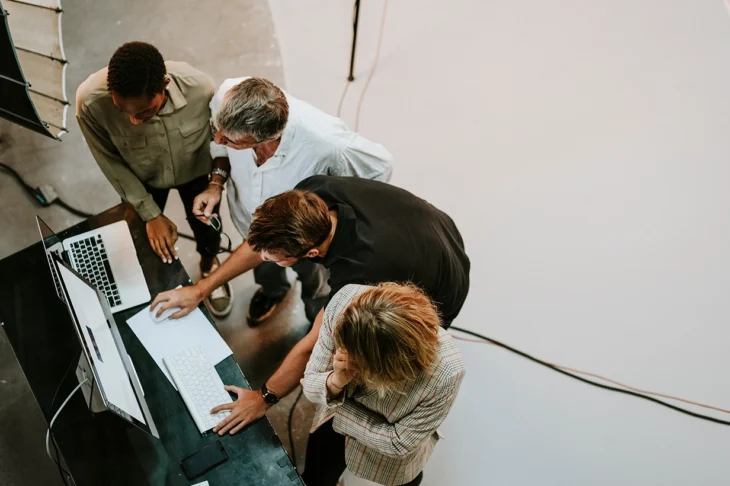 Team of marketers around a computer making a decision