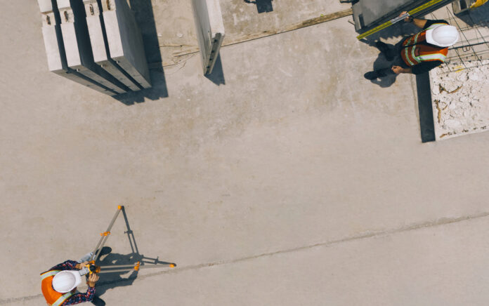 Worker filming worker with high vis jacket and safety helmet
